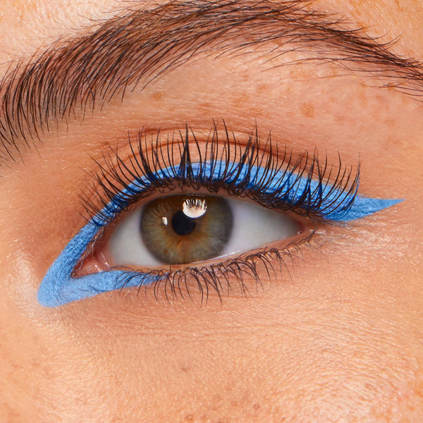 Prance ColourPop Crème Gel Liner tracing a vivid sky-blue graphic wing along the upper and lower lash lines, creating a sharp cat-eye on a close-up eye with long lashes.