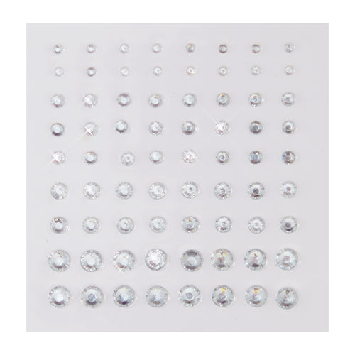 Clear round rhinestone stickers in graduated sizes sparkle on a white backing sheet, arranged in neat rows; ColourPop Crystal Face Jewels, Individual pack, self-adhesive crystals for customizable face and eye makeup looks.