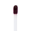Doe-foot applicator coated in deep berry plum pigment, showing the saturated, velvety finish of ColourPop Ultra Matte Lip in Currant Mood, captured in a close-up macro against a clean white background.