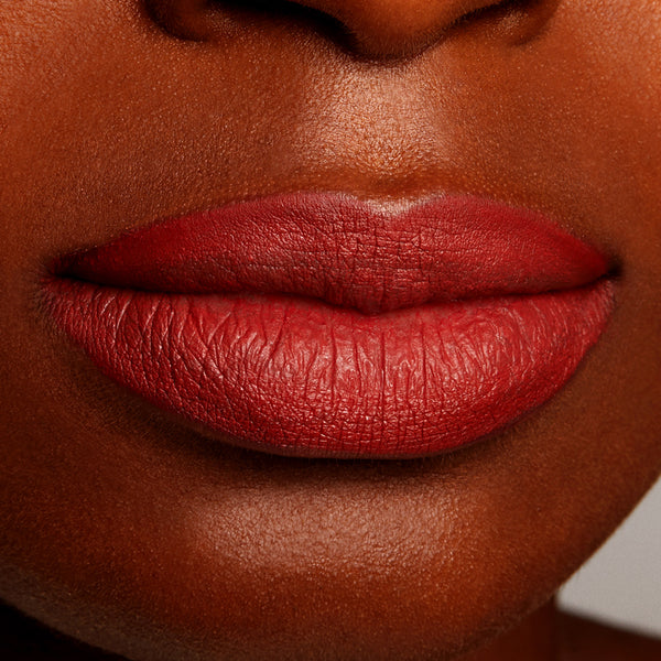 Full lips wear ColourPop Lippie Pencil Love Bug, a warm terracotta red, shown lined and filled with a matte finish in a tight studio close-up, highlighting smooth, precise edges and rich pigment for this lip liner swatch.