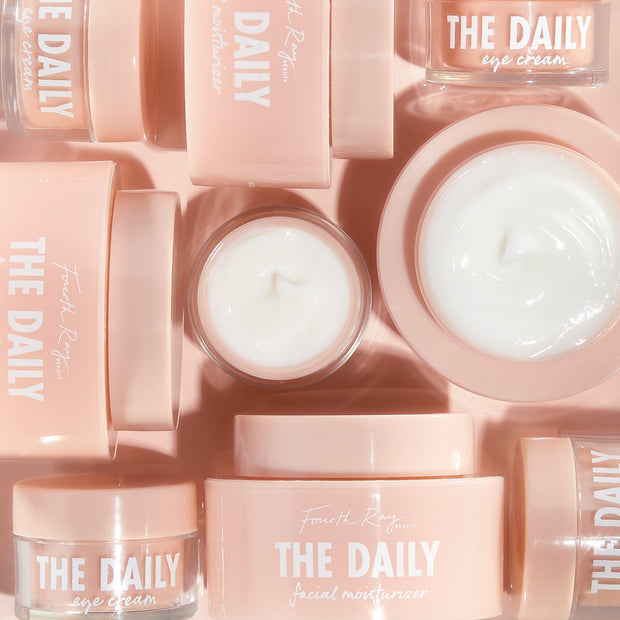 The Daily Face + Eye Cream set displays open and closed peach jars in a flat-lay grid, creamy white swirls visible, labeled THE DAILY by Fourth Ray Beauty - ColourPop Face & Eye Moisturizer Set styled on a blush backdrop.