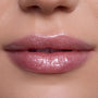 Close-up of lips wearing Bright Ariel Ultra Glossy Lip, a shimmering pink Disney Princess lip gloss with high-shine, reflective sparkle on smooth, fair skin, showcasing moisturizing, ultra-glossy finish for everyday glam makeup looks.