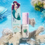 ColourPop Bright Ariel Ultra Glossy Lip from the Disney Princess collection standing on coral, with Ariel artwork on the mint box and shimmering gloss tube against an underwater-inspired blue background with bubbles and seashells.