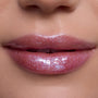 Close-up of lips wearing Courageous Rapunzel Ultra Glossy Lip, a shimmering pink Disney Princess lip gloss with high-shine, iridescent sparkle on smooth, hydrated lips against natural skin tone background.