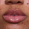 Close-up of freckled lips wearing Mademoiselle Belle Ultra Glossy Lip, a sheer pink Disney Princess lip gloss with high-shine, shimmery finish on medium skin tone, showcasing smooth, hydrated texture for beauty product detail.