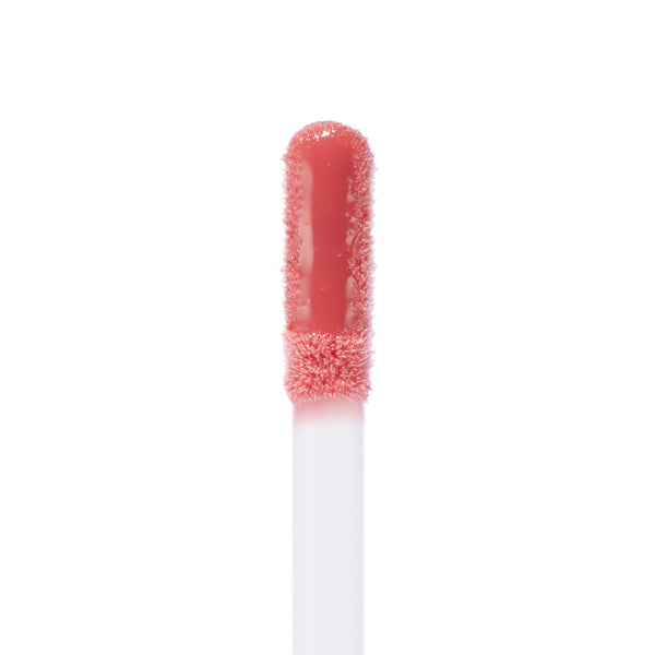 Doe-foot applicator coated in Ditto Ultra Glossy Lip, a peachy-pink high-shine ColourPop Ultra Glossy Lip, captured in a macro close-up on a white background highlighting the smooth glossy texture.