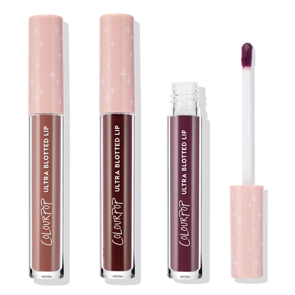 ColourPop Ultra Blotted Lip Edgy Vibes trio stands upright with one tube opened to show a doe‑foot applicator, on a white background; pink starry caps top nude rose, deep burgundy, and plum shades.