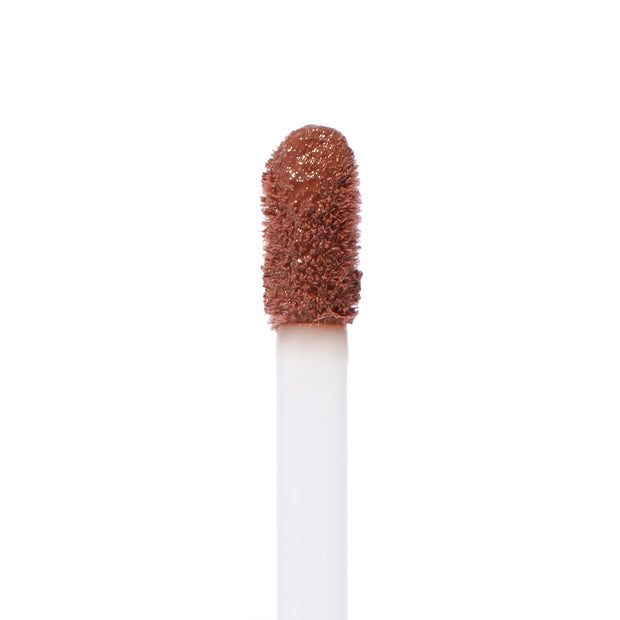 Doe-foot applicator swiped with Espresso Martini, a warm coffee-brown ColourPop Ultra Blotted Lip, showing diffused pigment and plush texture in a macro close-up on a white background.