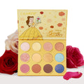 Beauty and the Beast ColourPop Shadow Palette opens to 12 pans - pink, gold, brown, and blue mattes and shimmers, including a rose-embossed shade - with Belle art on the yellow lid, set among red and pink roses on a white background.