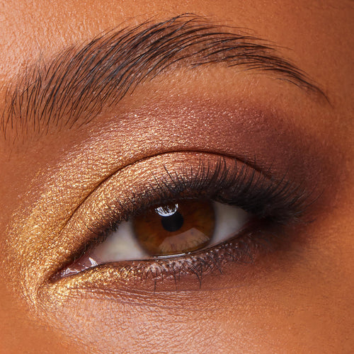 Close-up eye wearing warm metallic gold and copper shimmer blended into soft brown, showcasing the As Old As Time ColourPop Shadow Palette, Cheek, & Lip Set; inner corner highlighted and lashes natural in a studio beauty swatch.