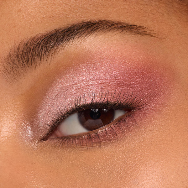 Eyelid wearing ColourPop Blush Baby shadow palette, shimmering rose-pink and soft mauve shades blended from inner corner to crease with a satin finish and defined lashes, shown in a macro close-up to display pigment and smooth texture.
