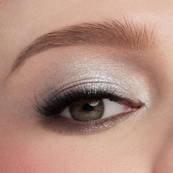 Metallic silver smoky eye showcasing the Gone Metal shadow palette, with foil-like shimmer across the lid, deeper gunmetal in the crease, and a soft inner-corner highlight; extreme close-up of one eye with long lashes; ColourPop Shadow Palette.
