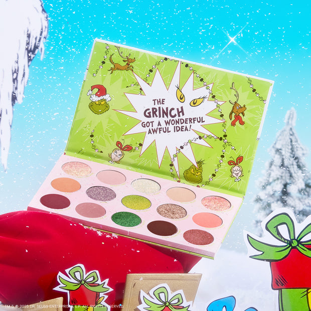Colourpop How the Grinch Stole Christmas shadow palette opens to show matte and shimmer greens, pinks, and neutrals in festive Grinch artwork, staged on a snowy holiday scene with gifts.