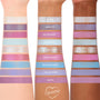 ColourPop In A Trance shadow palette swatches spanning three arms, showcasing pastel purples, pinks, and icy blues in matte, shimmer, and glitter finishes; shade names like Clarity, Mind’s Eye, Daydream BBY, Future Self, and Aura Again visible.