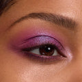 Shimmery violet‑magenta eyeshadow blends across the lid, crease, and lower lash line with a metallic inner‑corner highlight, showcasing the It’s My Pleasure ColourPop Shadow Palette in a tight macro of the eye and groomed brow.