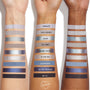 Three arms show swatches of the So Elemental ColourPop Shadow Palette, 12 cool‑toned shades in shimmer and matte - from lilac and icy silver to teal, cobalt, navy, and black - with shade names (Angelite to See Ya) labeled on the center arm.