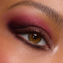 Close-up hazel eye wears a deep berry and plum smoky blend with soft shimmer and inner-corner highlight, created using A Shadow of Secrets Shadow Palette, a ColourPop Shadow Palette, showing bold pigment and smooth blend on lid and lower lash line.