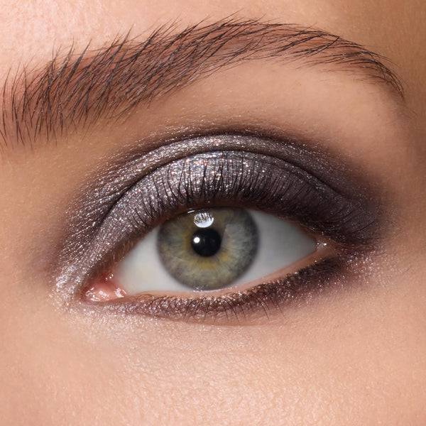 Shimmering silver smoky eye on a model, created with A Shadow of Secrets ColourPop Shadow Palette, metallic taupe and charcoal shades blended across the lid in a studio close-up to highlight the high-pigment shadow palette payoff.
