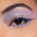 Shimmery lavender and periwinkle eye makeup showcases the Beach Dreamin’ ColourPop Shadow Palette, blending iridescent lilac across the lid with a soft crease fade and lower lash line accent in a studio close-up.