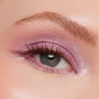 Shimmery pink-lilac eyeshadow sweeps across the upper lid and inner corner on a close-up gray eye, catching light and defining natural lashes and brow, showcasing Best Day Ever, a ColourPop Shadow Palette.
