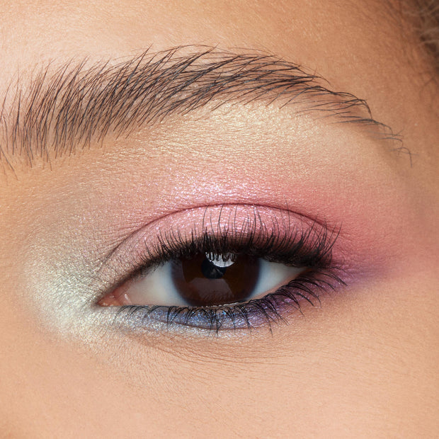 Shimmering pastel eye wearing The Toys Are Here ColourPop Shadow Palette, blending pearly mint inner corner into pink lid, rose-gold crease, and violet-blue lower lash line in a macro close-up with defined lashes and brow.