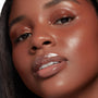 Glossy, plumped lips wearing It’s a Date, ColourPop So Juicy Plumping Glossy Lip Oil, catching light with a glass-like shine, shown in a close-up beauty shot with dewy skin and warm copper eyeshadow for a fresh, full-lip look.