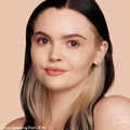 ColourPop Pretty Fresh Creamy Concealer in Fair 15 W smooths and brightens on a model’s face, showing natural dewy coverage; close-up against a peach backdrop highlights the fair warm shade and seamless blend.