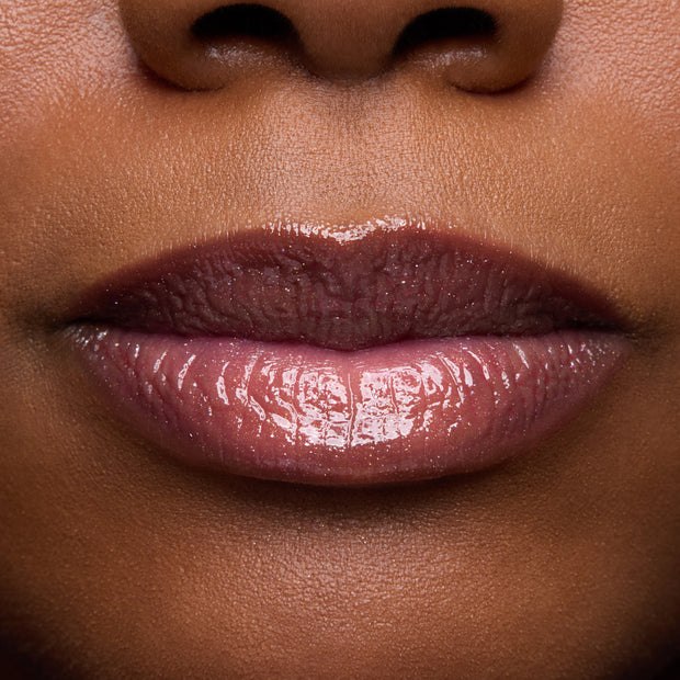Close-up swatches of Colourpop Fresh Kiss Glossy Balm in Chocolate Cherry on lip tones, showing sheer berry shine with subtle shimmer, promoting Lip Gloss & Lip Oil finish and smooth, hydrated lips.