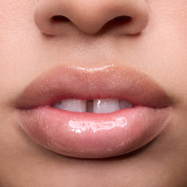 Close-up of models’ lips wearing Colourpop Fresh Kiss Glossy Balm in Whipped Cream, showing sheer nude shine and shimmer finish, highlighting Lip Gloss & Lip Oil texture on different skin tones against a plain background.