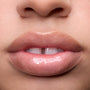 Close-up of models’ lips wearing Colourpop Fresh Kiss Glossy Balm in Whipped Cream, showing sheer nude shine and shimmer finish, highlighting Lip Gloss & Lip Oil texture on different skin tones against a plain background.