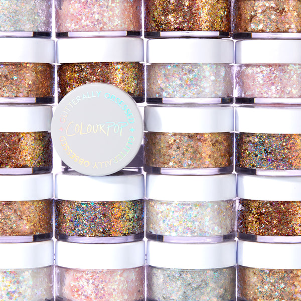 Disco Lady glitter gel features chunky iridescent sparkle in a clear base, shown in a round pot with a white, holographic ColourPop lid, set against a wall of stacked ColourPop Glitter Gel jars in assorted shades.