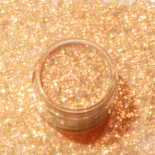 Clear jar of ColourPop Glitter Gel, Ogres are Like Onions, shimmering with warm golden glitter and green‑pink iridescence, shown open and surrounded by matching sparkle to showcase the dense, multidimensional gel texture.