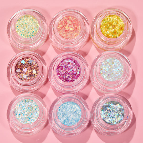 Nine Glitter Hour ColourPop Glitter Gel pots sparkle in a 3x3 grid, featuring iridescent white, icy blue, silver holo, mint, peach, yellow, rose gold with heart confetti, fuchsia, and opal mixes on a pastel pink background.