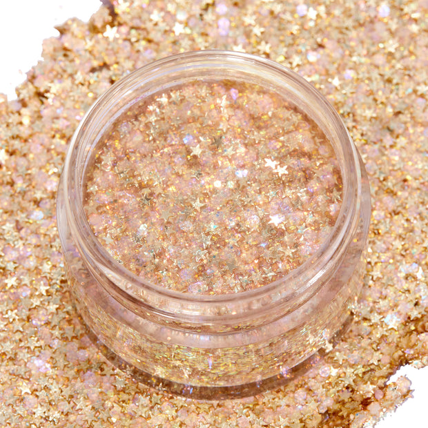 Open jar of ColourPop Glitter Gel in Spinner, showing densely packed iridescent gold glitter with star-shaped confetti, set atop a thick swatch of the same sparkly gel on a white background.