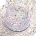 Open clear jar of Ur A Firework ColourPop Glitter Gel displaying a chunky‑fine mix of silver iridescent glitter and pastel holographic star confetti shimmering in a clear base, set atop a swatched bed of matching sparkle for face and body looks.