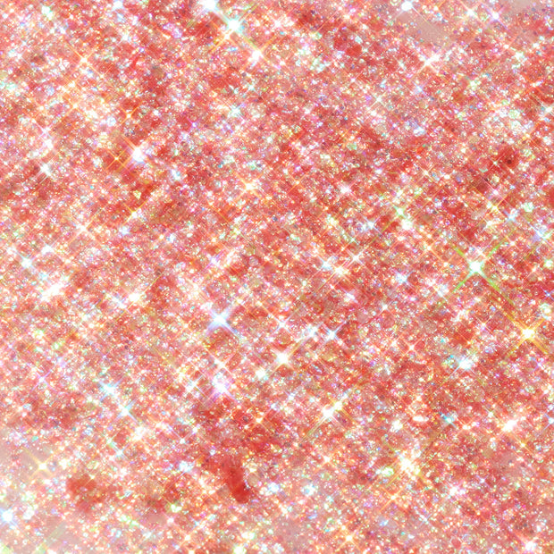 Floating Lights glitter gel swatch sparkles in a peach-pink base with dense iridescent rainbow flecks and starry reflections, shown in a macro flat-lay texture; ColourPop Glitter Gel delivers high-shine, multidimensional shimmer.