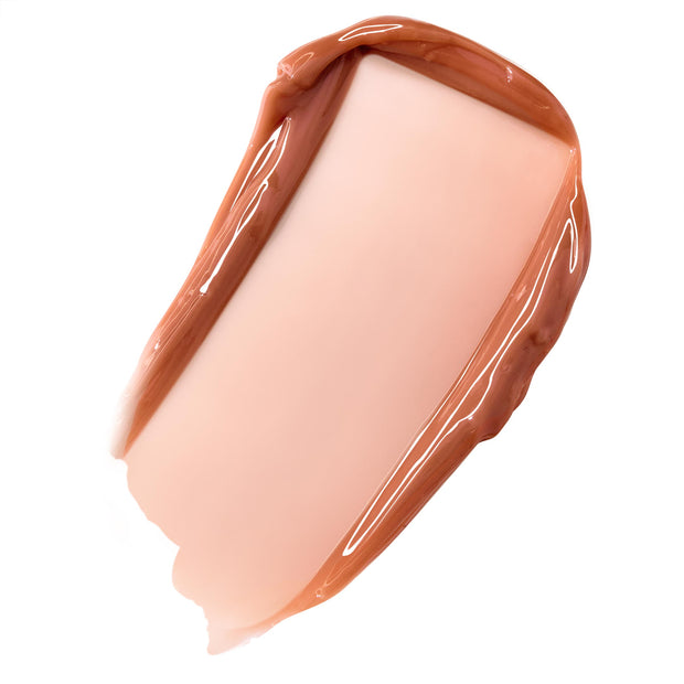 Glossy caramel nude balm swatch spreading in a smooth, high-shine swipe on white, showcasing ColourPop Fresh Kiss Glossy Balm in Caramel Latte, a sheer warm beige with a latte tint.