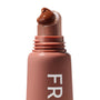 ColourPop Fresh Kiss Glossy Balm in Chocolate Milkshake oozing a dollop of rich chocolate-brown gloss from a slanted macro tip applicator, on a matte rosy squeeze tube with partial “FR” lettering, close-up on white.