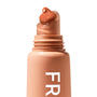 ColourPop Fresh Kiss Glossy Balm in Caramel Latte dispensing a caramel-brown dollop from a slanted rounded applicator tip, shown close-up on a peachy-nude tube with white “FR” lettering against a clean white background.