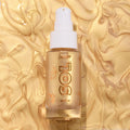 Clear glass bottle of ColourPop SOL Glow Oil, It’s a Wolf Thing, standing upright with a white pump and gold SOL logo, showcasing shimmering golden body oil against a swirled metallic gold backdrop.