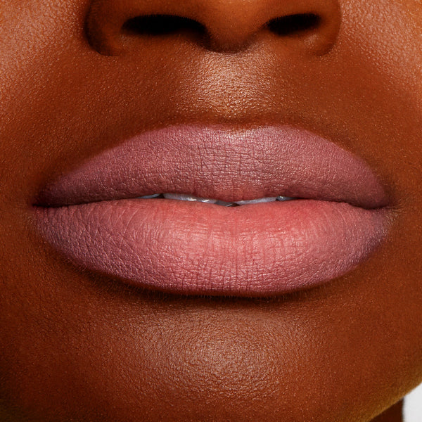 Lips wearing Good N Plenty ColourPop Lippie Pencil, a cool-toned mauve pink liner, filling and defining the lips with a smooth matte finish, shown in a close-up swatch on deep skin for true-to-color payoff.