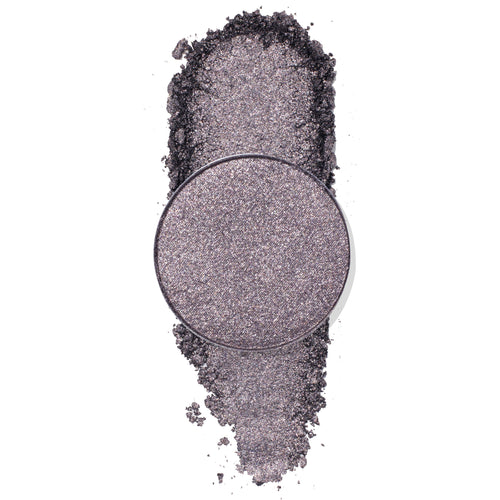 Goody Two-Shoes pressed powder shadow by ColourPop - shimmery gunmetal-lilac eyeshadow pan - rests over a vertical swipe of crushed pigment, showcasing its metallic sparkle on a clean white background.