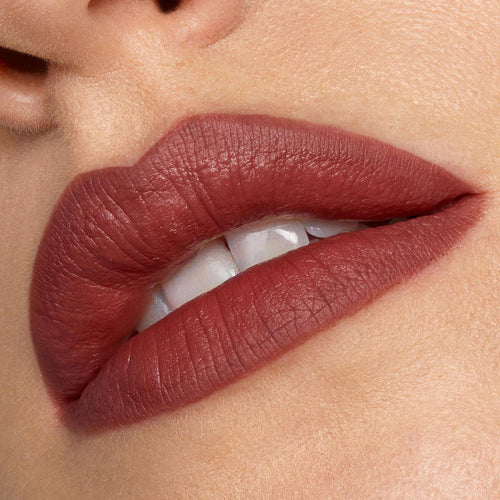 Full lips lined and filled with Grunge ColourPop Lippie Pencil, showcasing a soft-matte warm brown‑rose hue in a tight close-up with teeth slightly visible, emphasizing crisp edges and smooth, even coverage.