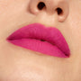 Lips wearing Heart On, a ColourPop Lippie Pencil, lining and filling the lips with a vibrant fuchsia pink matte finish in a tight close-up, showing smooth, even coverage and crisp edges.