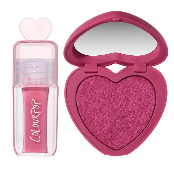 Heart to Get Sorry Not Sorry blush + UGL set showing a shimmery hot pink heart-shaped powder blush compact with built-in mirror beside a matching pink liquid lip gloss in a clear tube with heart-shaped cap on a white background.