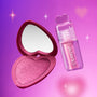 Heart to Get Sorry Not Sorry blush + UGL set showing a shimmery pink heart-shaped blush compact with mirror beside a glossy pink lip product with heart-shaped cap, floating against a glowing purple-pink background with soft sparkles.