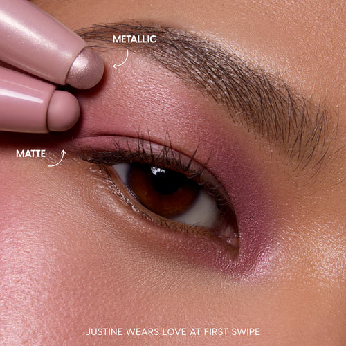 Close-up of a brown eye wearing rosy pink matte and metallic shimmer from the All Eyes On Me Shadow Stix Set, showing how the Heart to Get dual Shadow Stix glide on smoothly for a soft, blended eye look.