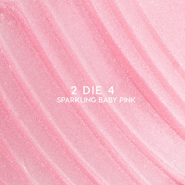 Heart to Get 2 Die 4 ultra glossy lip swatch showing sparkling baby pink shimmer in diagonal, textured streaks against a smooth pastel background, highlighting the high-shine, glittery finish for US makeup lovers.