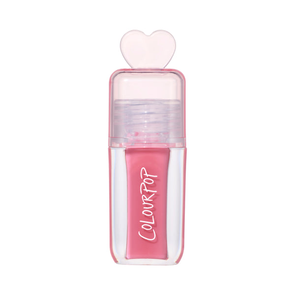 ColourPop Still That Girl ultra glossy lip in pink, standing upright with a clear rectangular tube, heart-shaped cap, and Heart to Get inspired packaging on a clean white background for a modern makeup product shot.