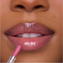 Close-up of a model applying Heart to Get Your New Obsession Ultra Glossy Lip, a high-shine pink lip gloss, with a doe-foot applicator on smooth, full lips for a juicy, plumped finish.